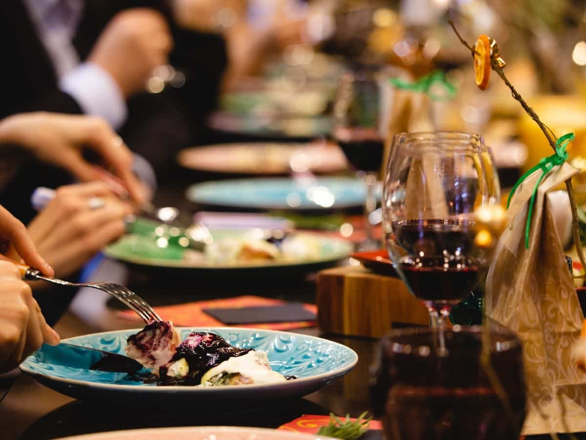 Scène de restaurant avec des invités profitant d'un repas, illustrant l'impact des relations presse pour booster la visibilité d'un établissement à Bordeaux.